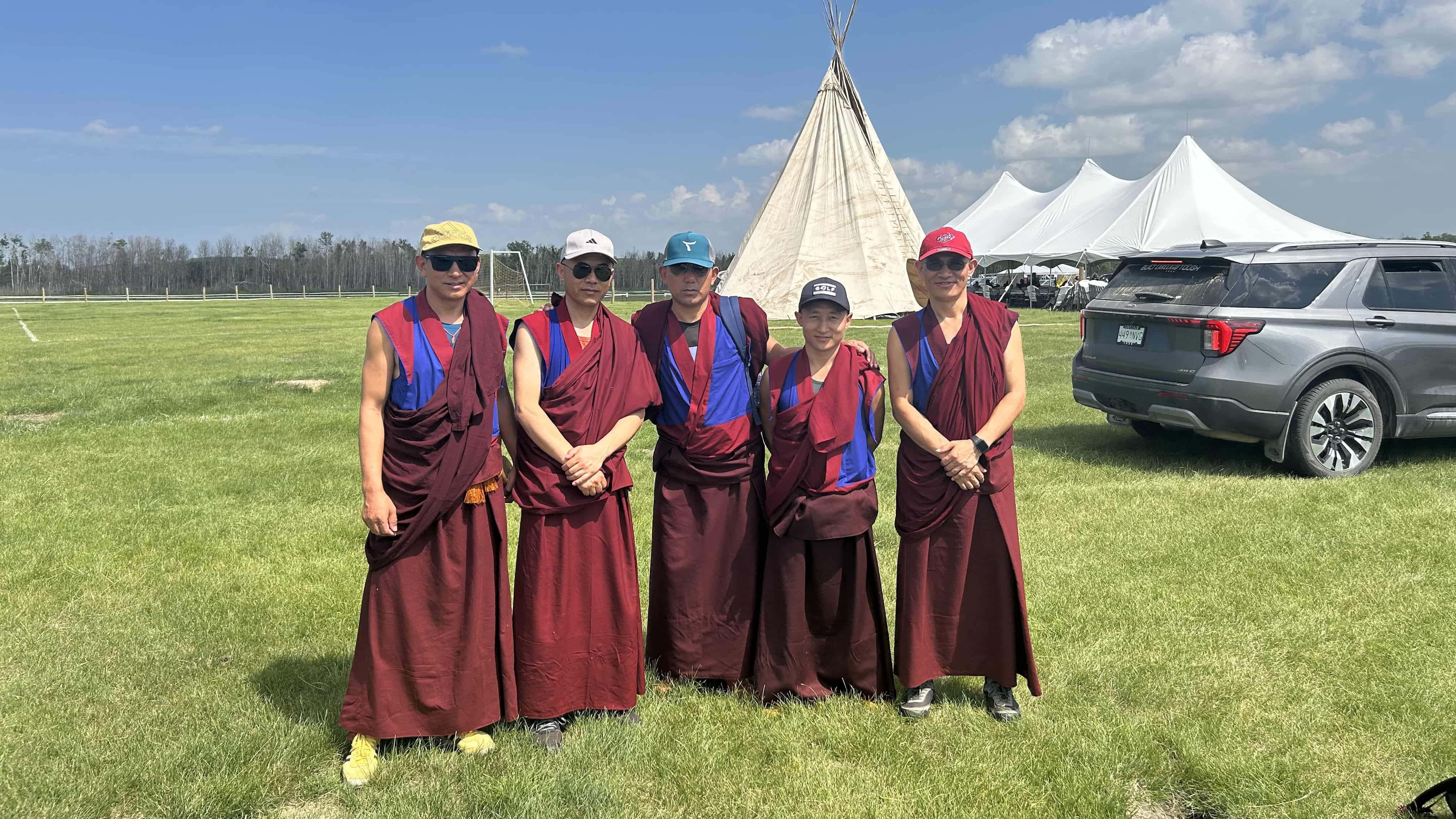 Five monks pose outside of a teepee set up for Ahtahkakoop's Family Day celebrations.