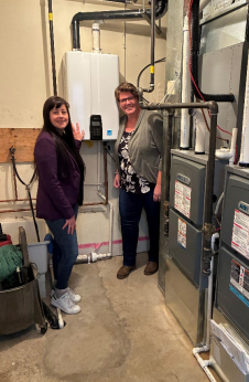 Councillor Chrystal Widsten and Mayor Kate Potter in the Council Chambers utility
room, where high-efficiency mechanical equipment was installed as part of the project.
