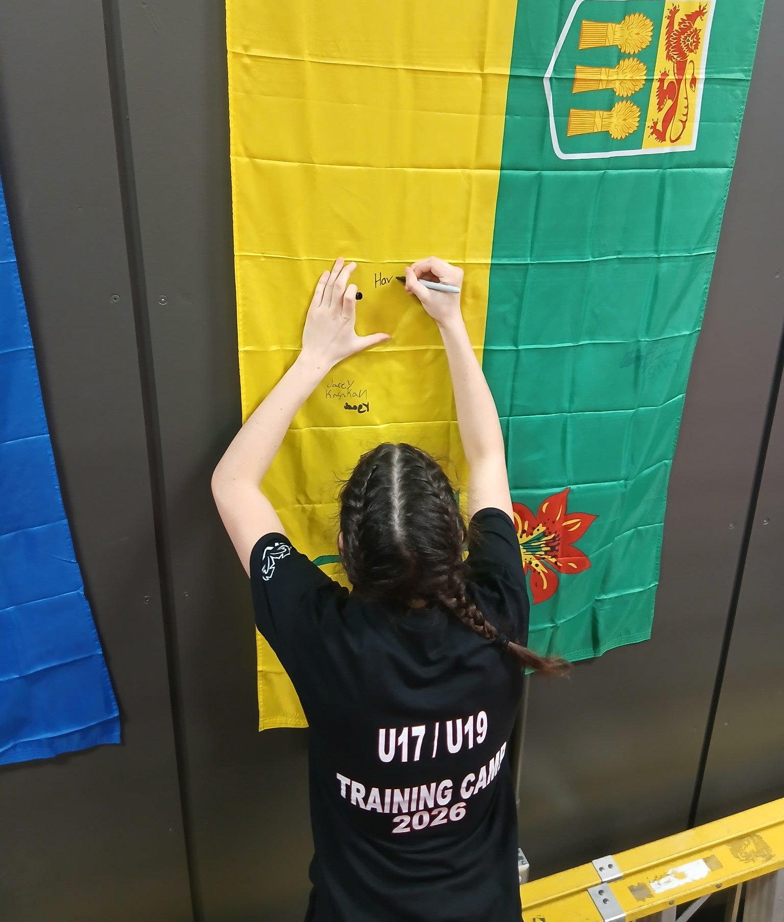 Havanna Demers of Rapid View signs a Saskatchewan flag during a high-performance boxing camp at Boxing Canada’s National Training Centre in Montreal.