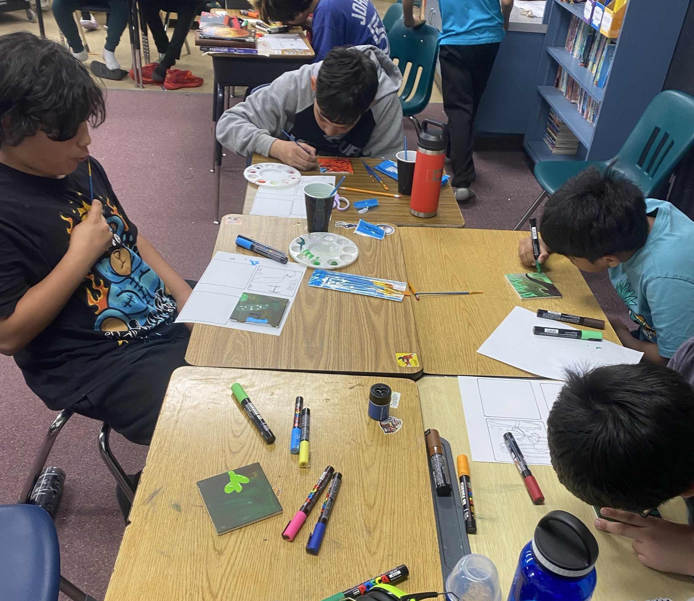 Grade 6 students are seen working on their tiles for the mural.