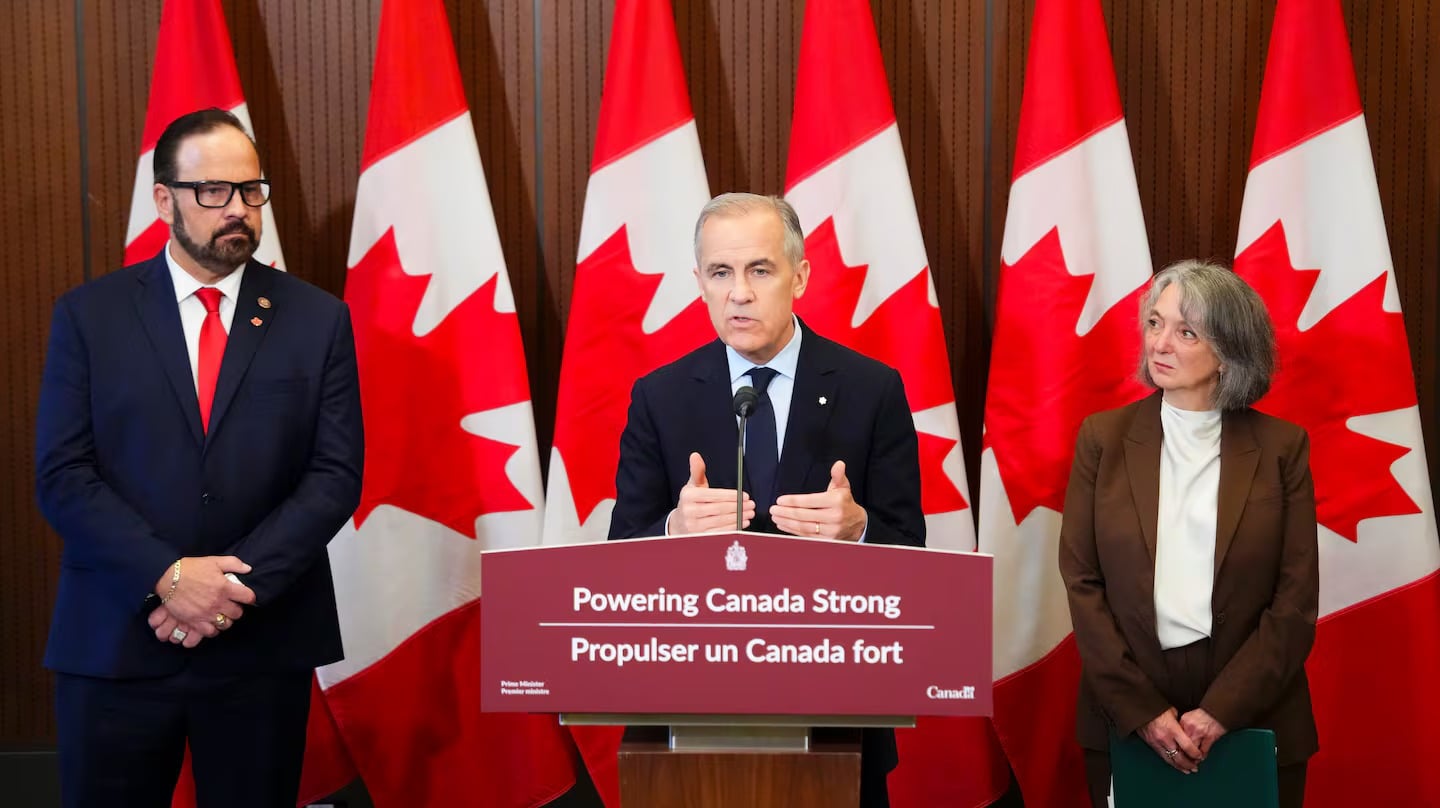 Prime Minister Mark Carney makes an announcement alongside Russ Shewchuk International Vice -President for International Brotherhood of Electrical Workers (IBEW) First District, left, and Minister of Environment and Climate Change Julie Dabrusin, right, on Parliament Hill in Ottawa on Thursday, May 14, 2026.