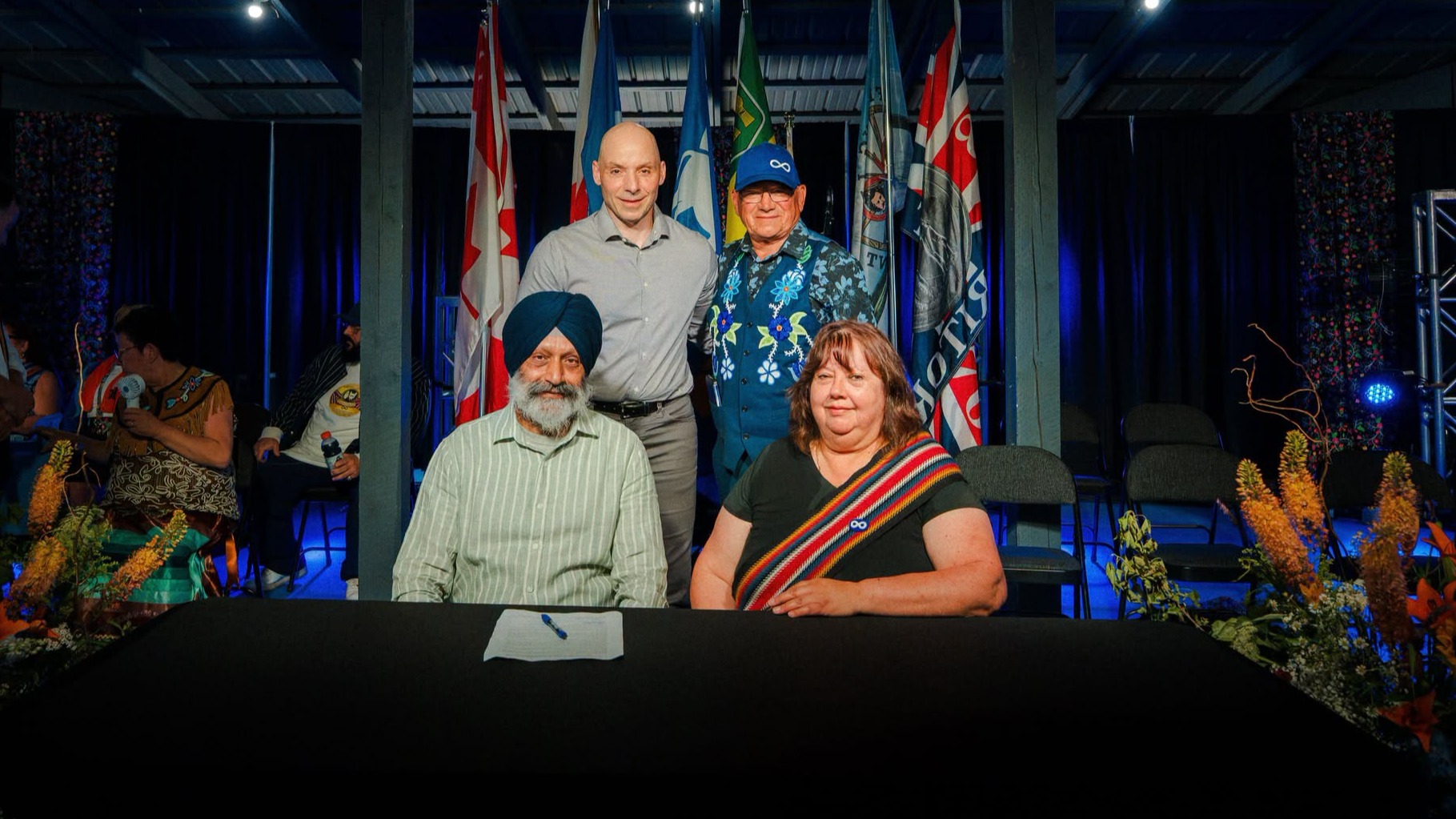 USask president Vince Bruni-Bossio (back left) stands with Glen McCallum as representatives from the University and MN-S sign the agreement.