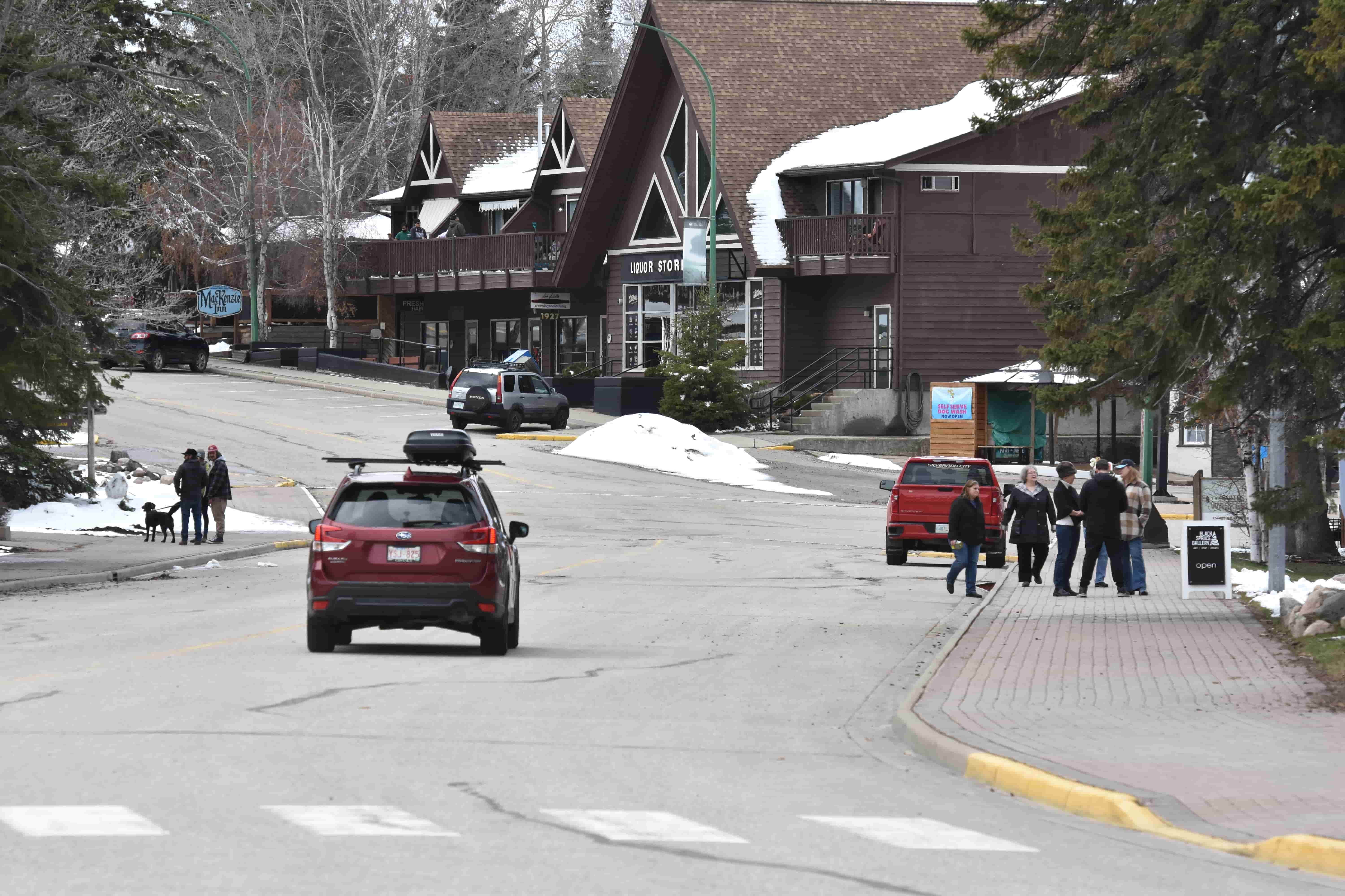 A car drives down a nearly deserted Waskesiu Drive, which would normally be packed with other vehicles along with pedestrians for the long weekend.
