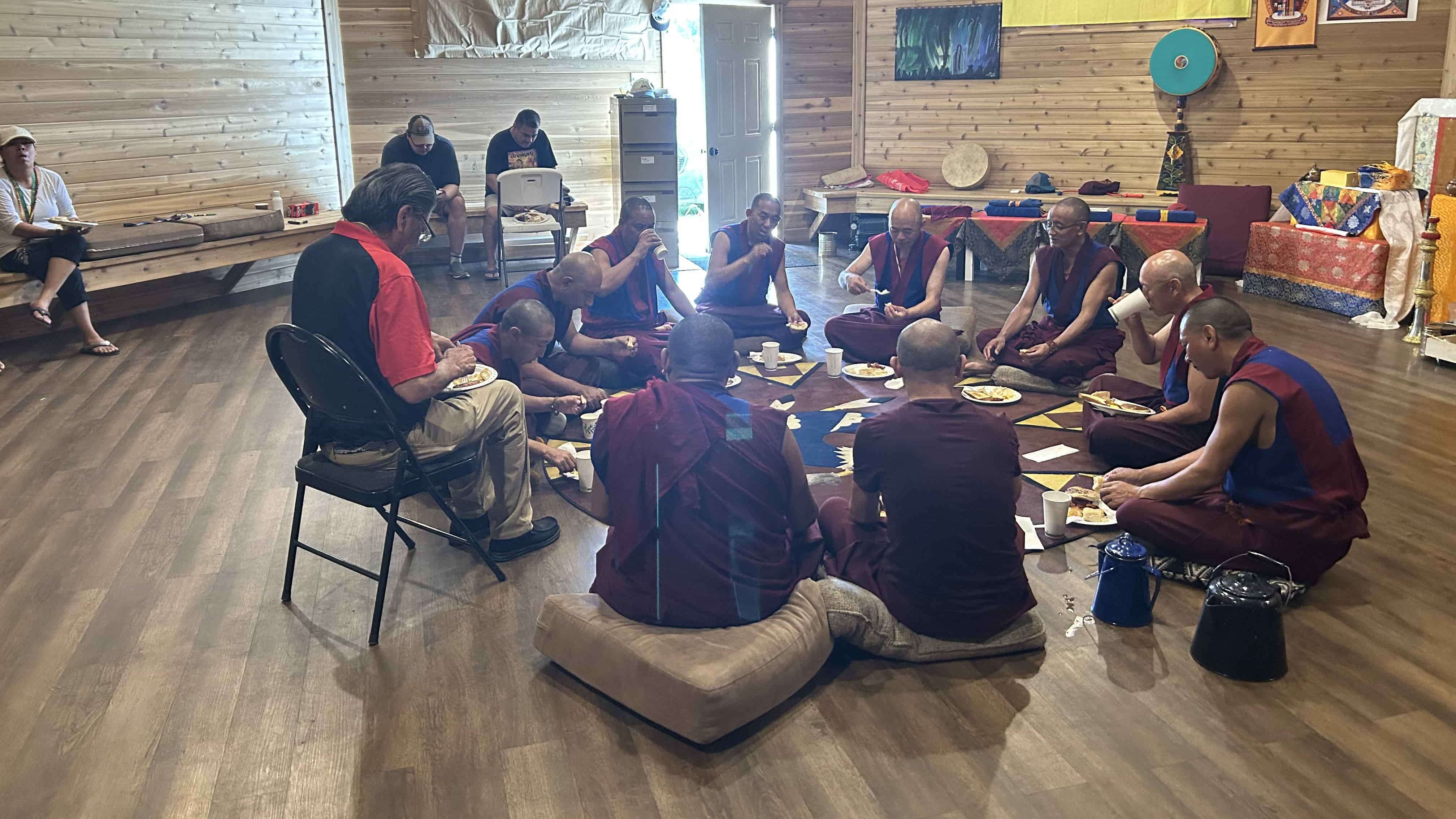 Alex Ahenikew sits with the monks and enjoys a breakfast of eggs, bacon, sausage, pancakes, and freshly made bannock, along with other members from Ahtahkakoop around the outside.