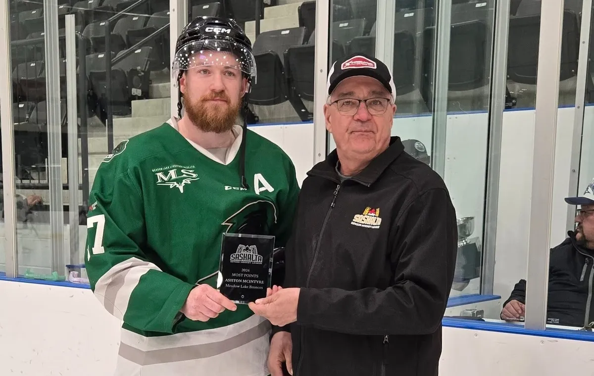 Ashton McIntyre, left, receives the SaskAlta Hockey League scoring title from league president Murray Cochrane.