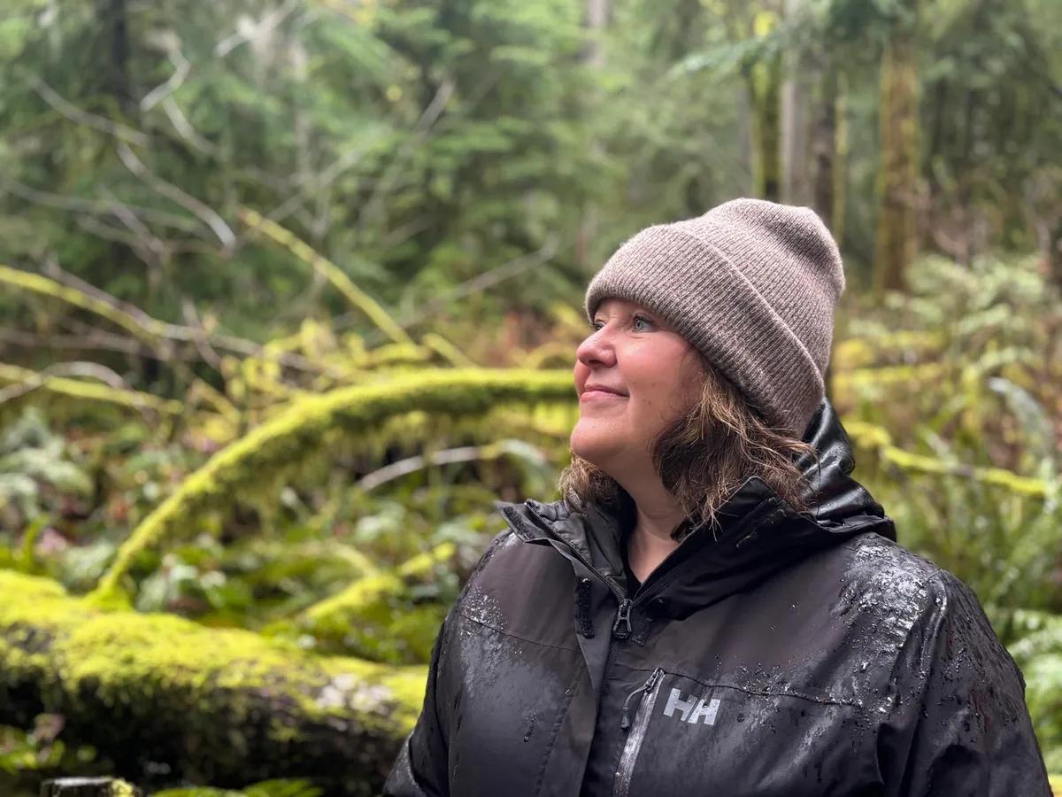 Parks and Environment Minister Tamara Davidson scans towering old growth Cedar and Douglas Fir trees while walking through Cathedral Grove during a rainy Thursday, March 19.