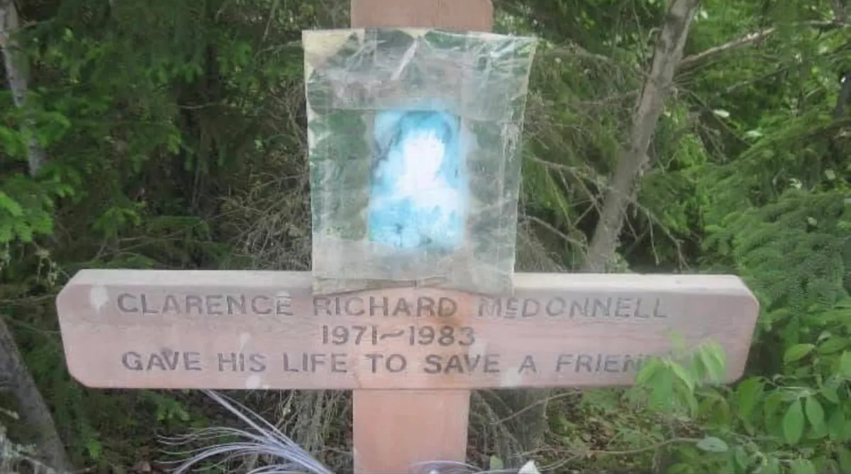 The wooden cross along the highway near the bridge.